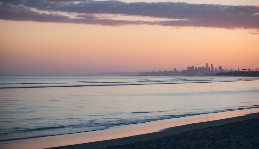 A serene beachfront with a calming sunset, a peaceful ocean, and a distant silhouette of Oceanside, CA's cityscape